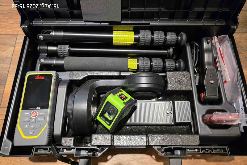 Geöffneter Koffer mit Kreuzlinienlaser, Stativbeinen und einem Leica Laser-Entfernungsmesser